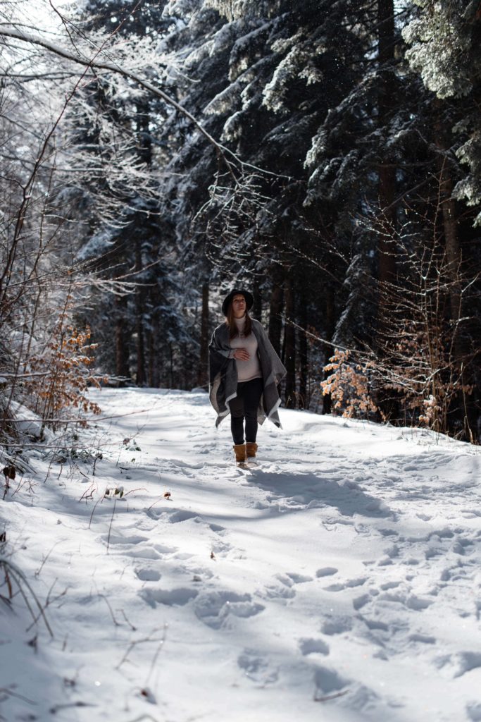 Femme enceinte dans une foret enneigée