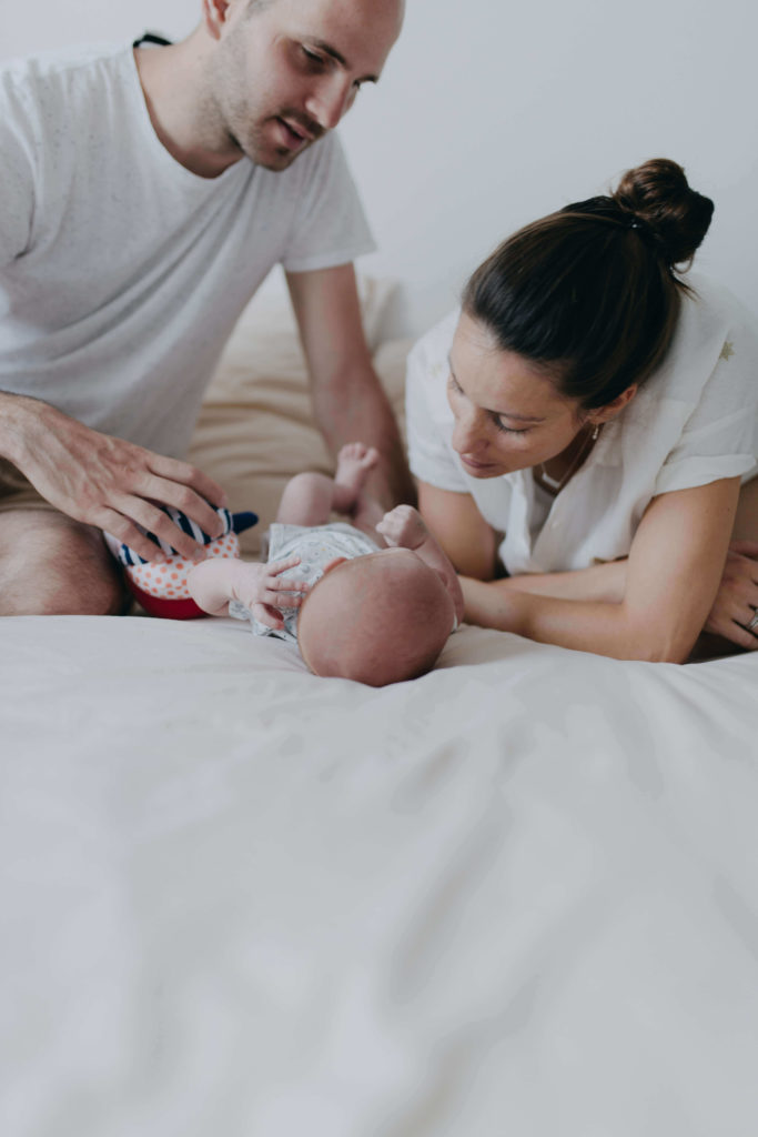 Maman papa et nouveau né sur le lit