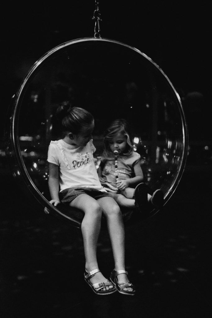 Deux petite fille dans un fauteuil rond suspendu