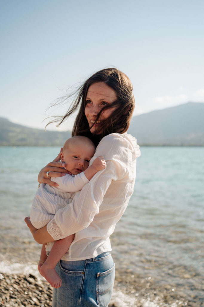 nourrisson dans les bras de sa maman au bord du lac d'Annecy