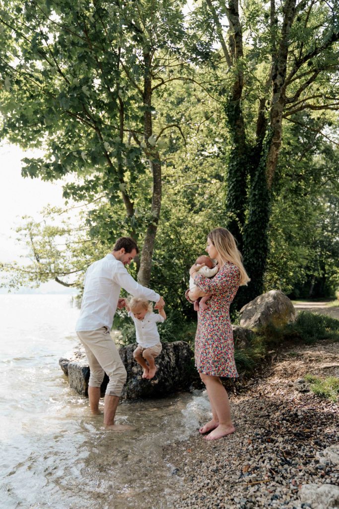 famille sui joue au bord de l'eau