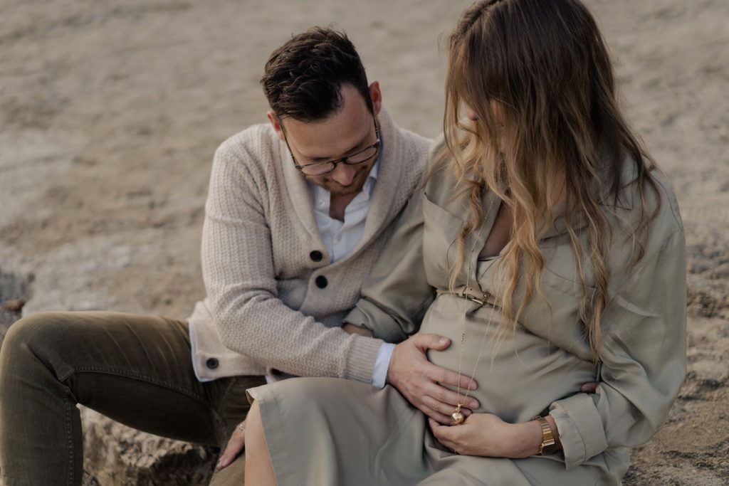 homme qui passe la main sur le ventre de sa femme enceinte